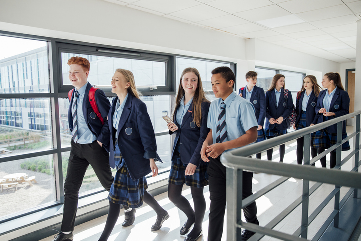 Secondary school children walking through school corridor